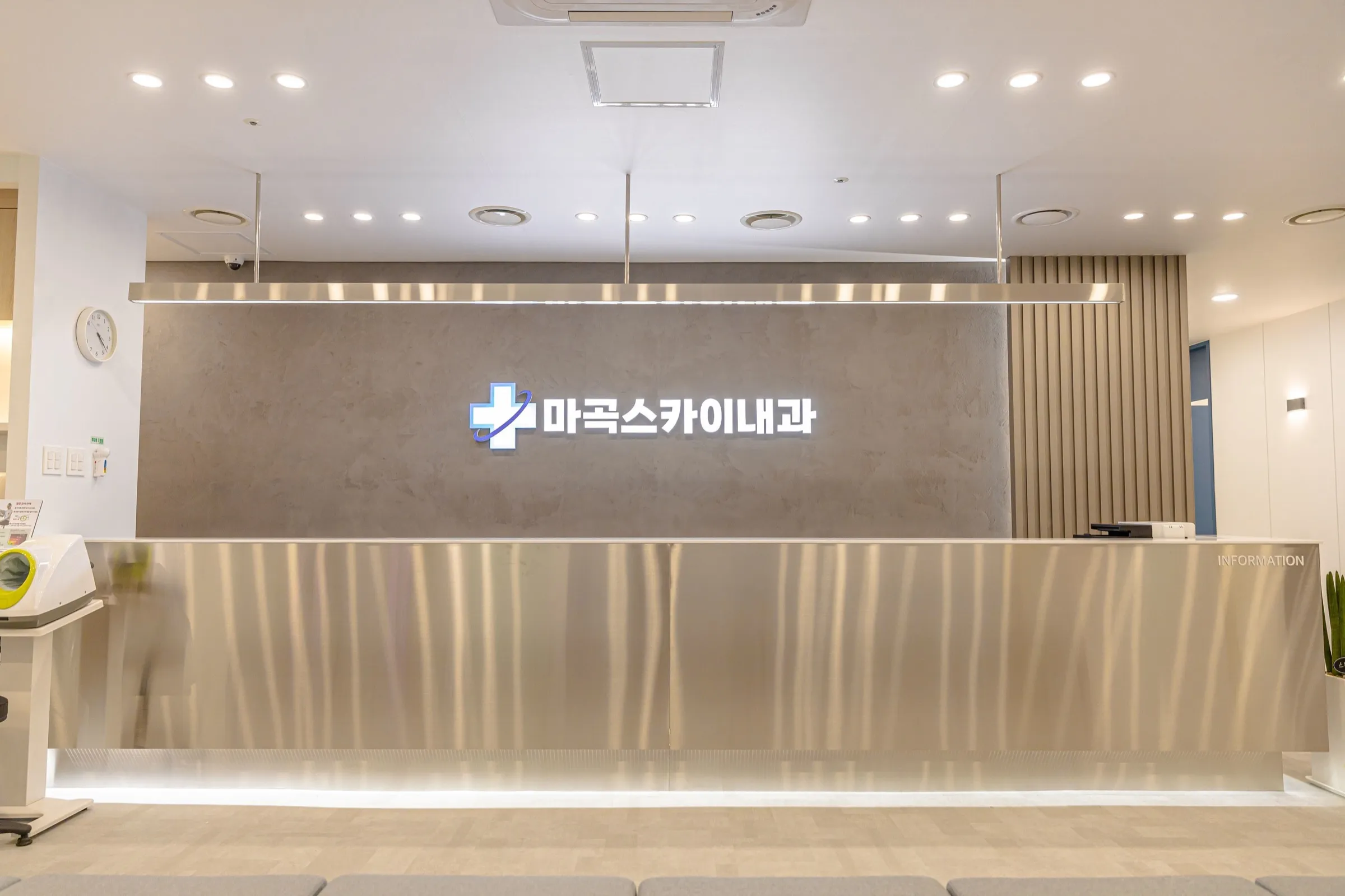 접수 · 수납 창구 정면 — 창구 위에 걸린 병원 로고 사인